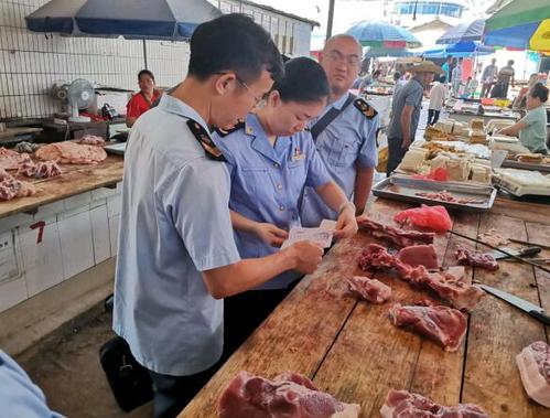 执法人员检查食用农产品批发市场猪肉摊位